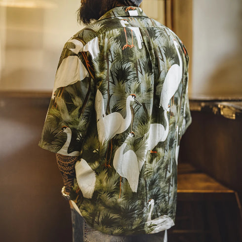 Person wearing a shirt with a nature-themed design featuring birds and foliage.